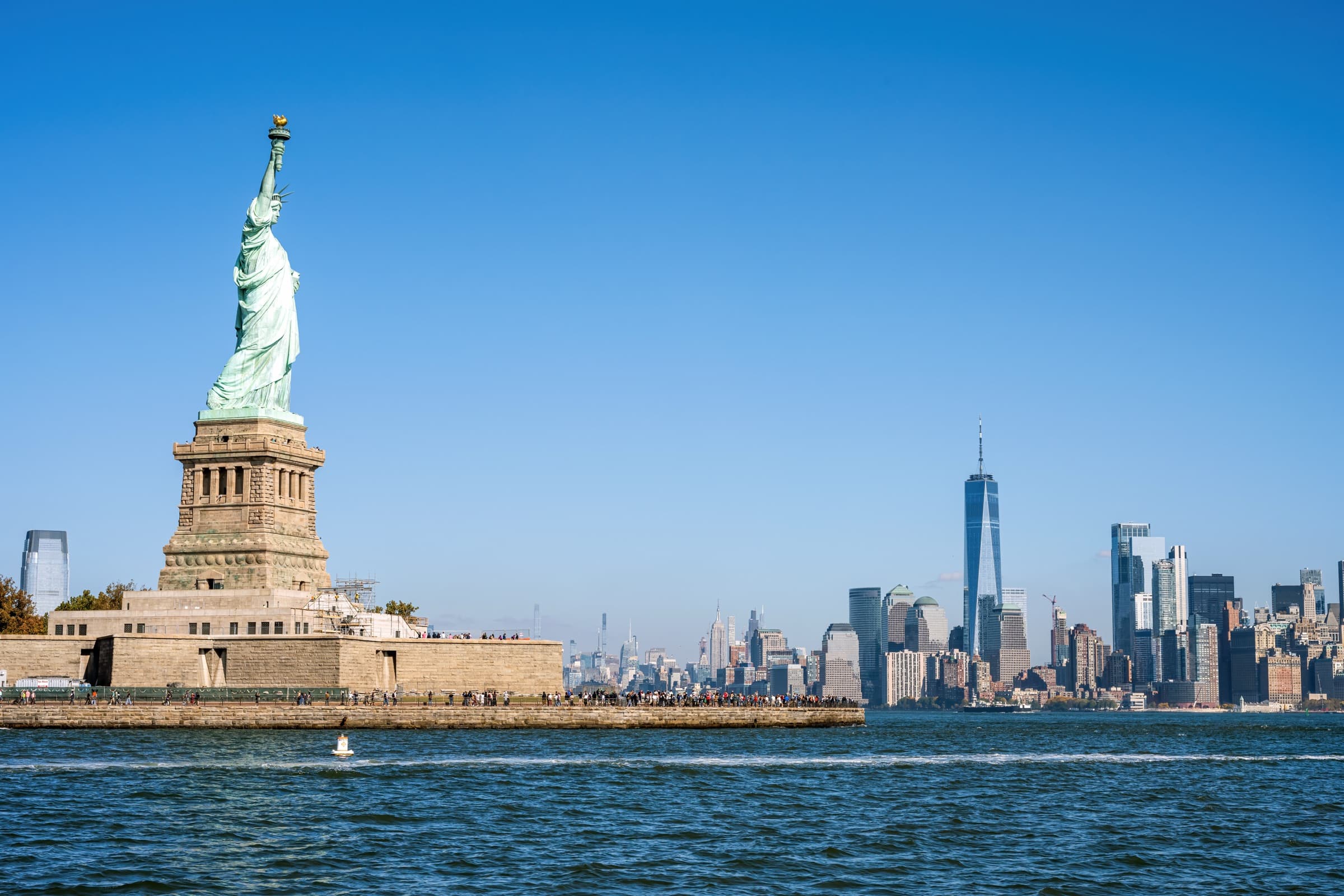 Tall ship under full sail passing the Statue of Liberty, New York Harbor